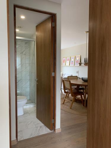 a bathroom with a door leading to a dining room at New Apartment in the heart of Polanco in Mexico City