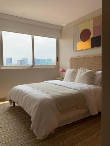 a bedroom with a large bed with a large window at New Apartment in the heart of Polanco in Mexico City