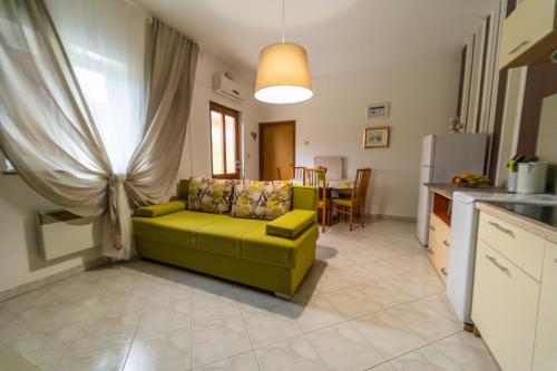 ein Wohnzimmer mit einer grünen Couch in einer Küche in der Unterkunft Apartments with a parking space Labin - 14581 in Labin