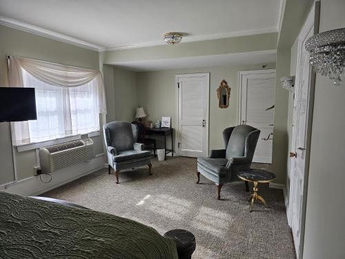 a bedroom with a bed and two chairs and a desk at Lowell Inn in Stillwater