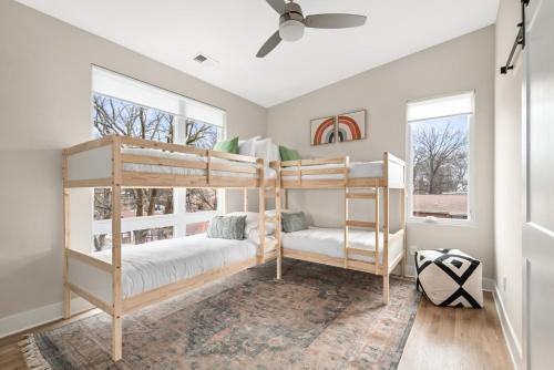 a bedroom with two bunk beds and two windows at Serene Boho Chic Home-Mins to DT in Nashville