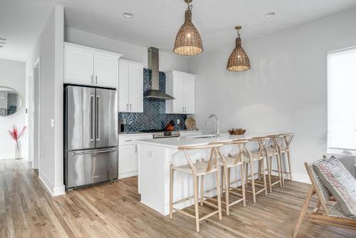 a kitchen with white cabinets and a stainless steel refrigerator at Serene Boho Chic Home-Mins to DT in Nashville
