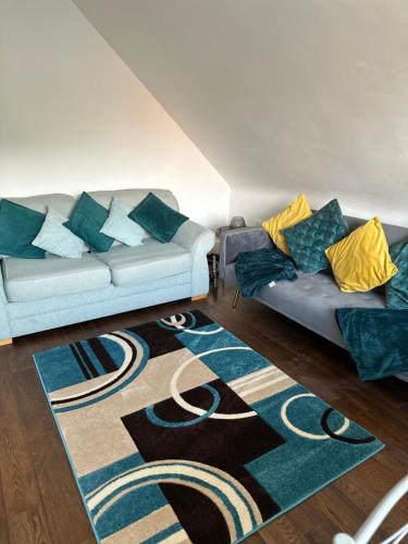 una sala de estar con 2 sofás y una alfombra en Lancaster Heights en Woodhall Spa