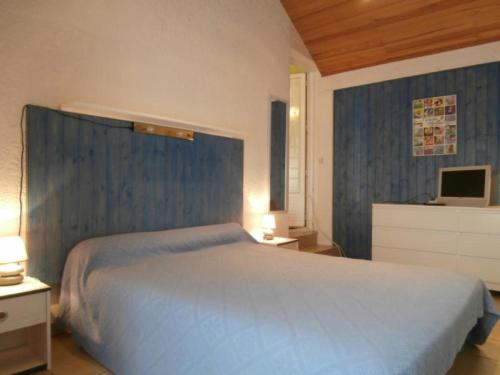 1 dormitorio con 1 cama blanca grande y TV en Maison Seignosse, 2 pièces, 4 personnes - FR-1-239-425 en Seignosse