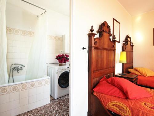 a bathroom with a bed and a washing machine at Charming apartment in Santa Giustina with shared swimming pool in Santa Giustina