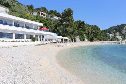 a beach with a building and the water at Apartments by the sea Zivogosce - Porat, Makarska - 21141 in Živogošće