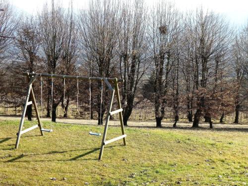 an empty swing set in a field with trees at Apartment in Valbelluna with Pool & Dolomites View in Santa Giustina