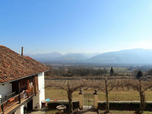 a house with a view of a field and mountains at Apartment in Valbelluna with Pool & Dolomites View in Santa Giustina