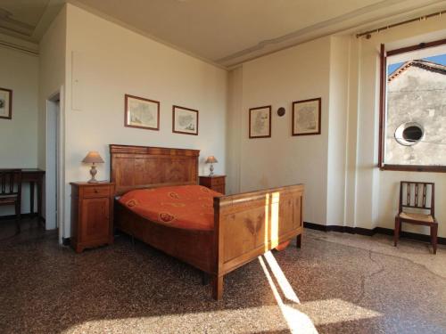 a bedroom with a wooden bed and a window at Spacious apartment in Santa Giustina with shared swimming pool in Santa Giustina