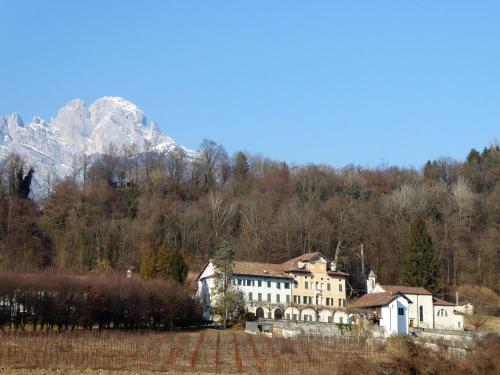 a large white house in front of a mountain at Apartment in Valbelluna with Pool & Dolomites View in Santa Giustina