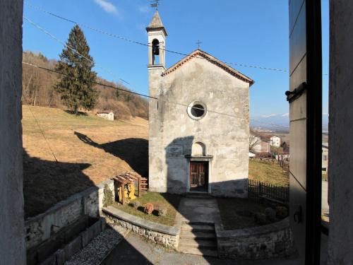 a small church with a steeple on a hill at Apartment in Valbelluna with Pool & Dolomites View in Santa Giustina