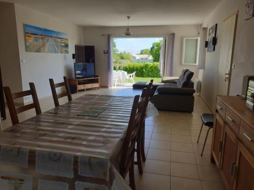 une cuisine et un salon avec une table et un canapé dans l'établissement Maison spacieuse avec jardin, à 5 km de la plage, Wifi et tout confort - FR-1-336-50, à Le Bernard