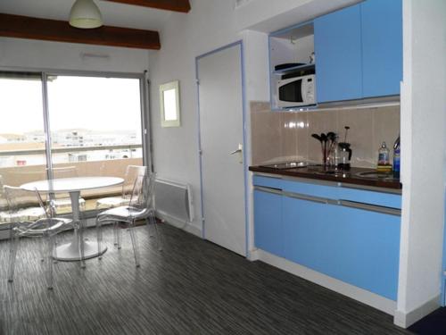 セットにあるAppartement Sète, 2 pièces, 5 personnes - FR-1-338-123のキッチン(青いキャビネット、テーブル付)