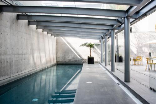 a swimming pool in a building with a table and chairs at New Modern Apartment in Polanco in Mexico City