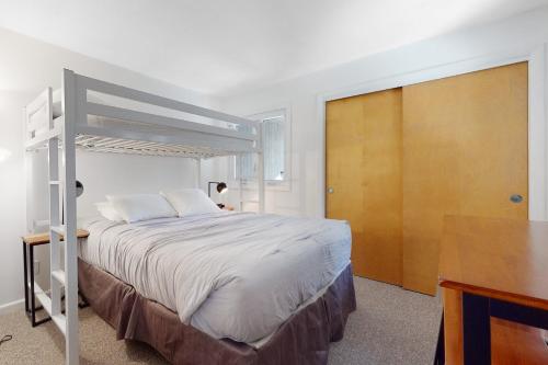 a bedroom with a white bed and a wooden door at Sunset Side in Campton