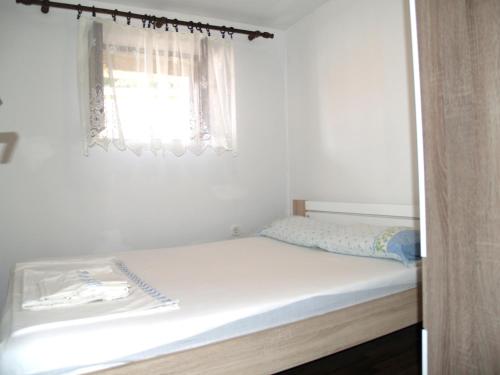 Bett in einem Zimmer mit Fenster in der Unterkunft Apartments with a parking space Tkon, Pasman - 20400 in Tkon