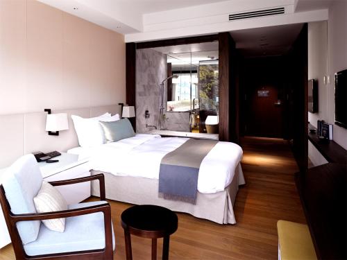 西海市にあるオリーブベイホテルのベッドルーム(大きな白いベッド1台、椅子付)