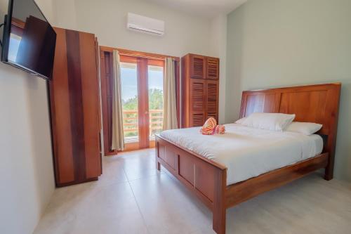 a bedroom with a bed and a large window at Suite 2 at Island Pearl Gold Standard Certified in Caye Caulker