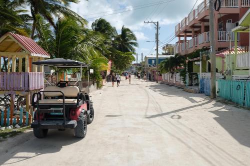 a golf cart parked on the side of a street at Suite 2 at Island Pearl Gold Standard Certified in Caye Caulker