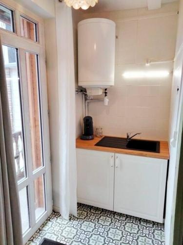 une cuisine avec un comptoir, un évier et une fenêtre dans l'établissement Appartement avec balcon / jardin, à Mers-les-Bains