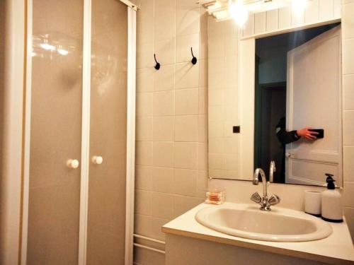 une personne prenant une photo d'une salle de bains avec lavabo dans l'établissement Appartement avec balcon / jardin, à Mers-les-Bains