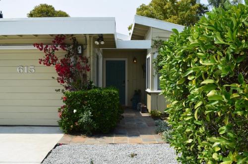 a green house with a door and a hedge at Silicon Valley Palo Alto Stanford Prime Location in Palo Alto