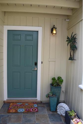a green door on a house with potted plants at Silicon Valley Palo Alto Stanford Prime Location in Palo Alto