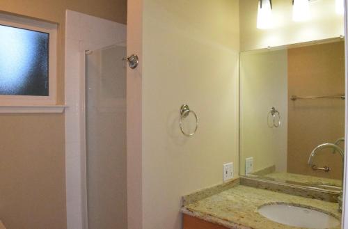 La salle de bains est pourvue d'un lavabo et d'un grand miroir. dans l'établissement Silicon Valley Palo Alto Stanford Prime Location, à Palo Alto