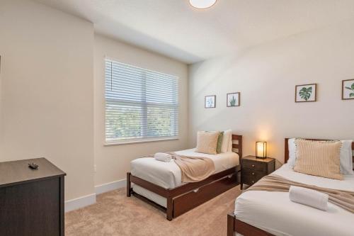 - une chambre avec 2 lits et une fenêtre dans l'établissement 4 bedrooms pool home Hidden Forest Resort Amenities, à Orlando