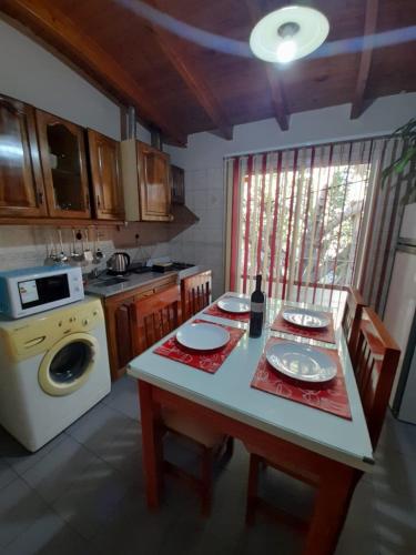 a kitchen with a table and a stove and a dishwasher at Departamento Los Girasoles in Guaymallen
