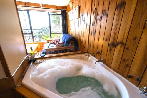 a large bath tub in a room with a window at Palm Beach - SupaCute Cottage Free Wifi in Palm Beach