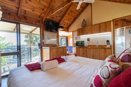 a bedroom with a large bed and a large window at Palm Beach - SupaCute Cottage, Sky TV, Wifi and possibly a Car in Palm Beach