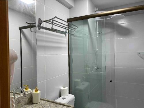 uma casa de banho com uma cabina de duche em vidro e um WC. em Flat encantador no Manaira Apart Hotel 1301 em João Pessoa