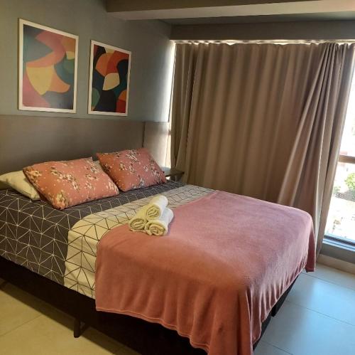 um quarto com uma cama e uma janela em Flat encantador no Manaira Apart Hotel 1301 em João Pessoa