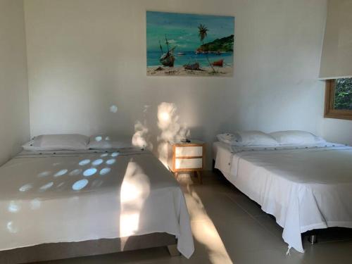 - une chambre avec 2 lits et un tableau mural dans l'établissement Casa Paraiso del Lago, à Prado