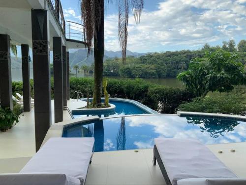 een huis met een zwembad met uitzicht op een rivier bij Casa Paraiso del Lago in Prado