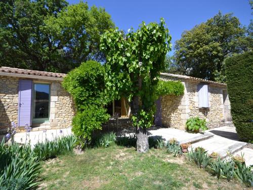 a stone house with a tree in the yard at Holiday home with garden and private pool in Vaison-la-Romaine