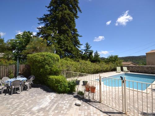 a pool with a table and chairs next to a fence at Holiday home with garden and private pool in Vaison-la-Romaine