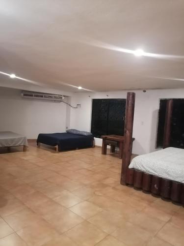 een kamer met 2 bedden en een schoolbord aan de muur bij Casa con vista y alberca privada in Acapulco