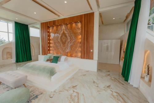a bedroom with a bed and a large painting on the wall at Villa Cella Bella Ubud in Ubud