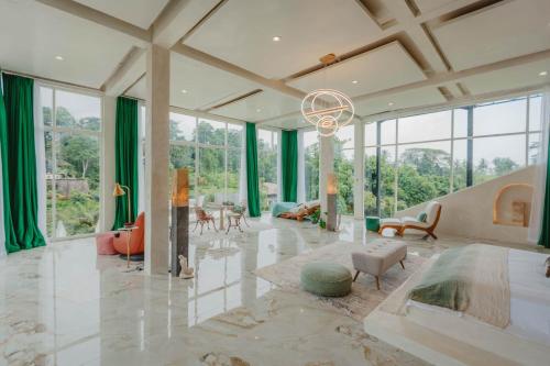 a large living room with green curtains and a chandelier at Villa Cella Bella Ubud in Ubud