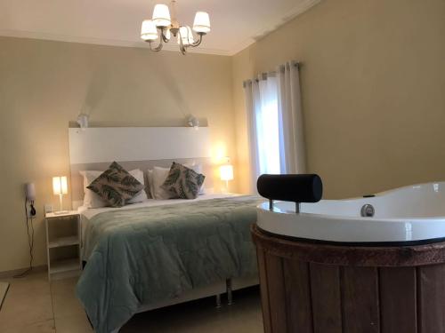 een slaapkamer met een bed en een bad bij Pousada Quinta dos Doges in Valença