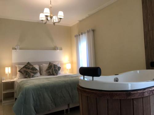 1 dormitorio con cama y bañera en Pousada Quinta dos Doges en Valença