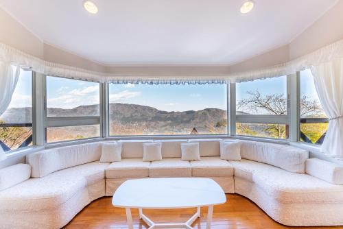a living room with a couch and large windows at Noёl HAKONE GENSEN in Hakone