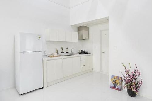 a white kitchen with a refrigerator and a sink at Meteora Pension in Damyang