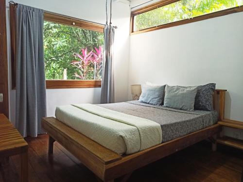 a bed in a room with a window and a bed sidx sidx sidx at Chilamate Holiday House in Puerto Viejo