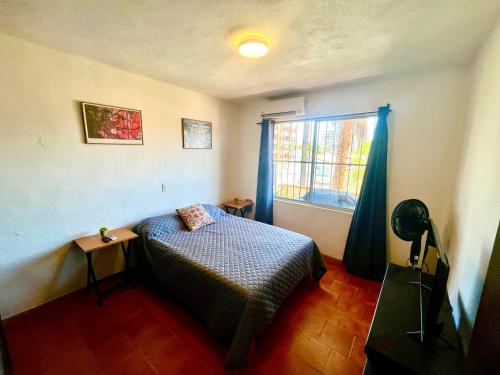 a small bedroom with a bed and a window at beautiful apartment with the best location in Puerto Vallarta