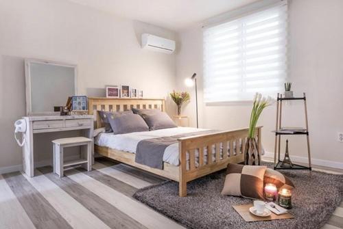 1 dormitorio con cama de madera y escritorio en Meteora Pension en Damyang