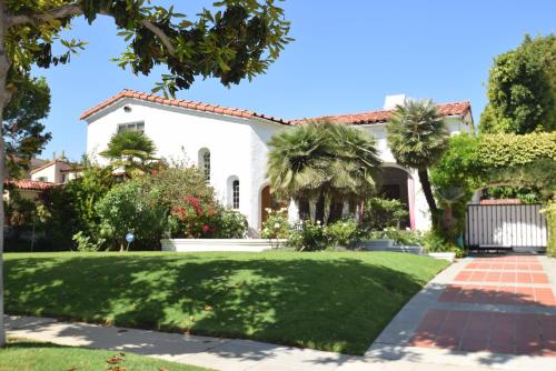 a white house with palm trees and a lawn at Beverly Hills Celebrity Home in Los Angeles