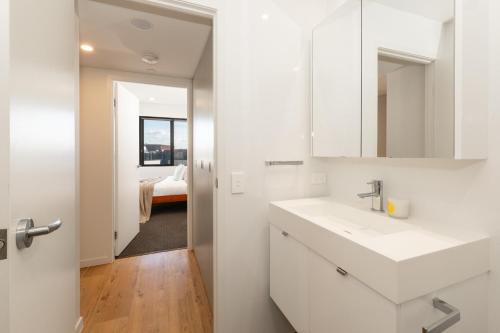 a white bathroom with a sink and a mirror at Prime Location Compact 1BD Apartment at Southbank in Brisbane
